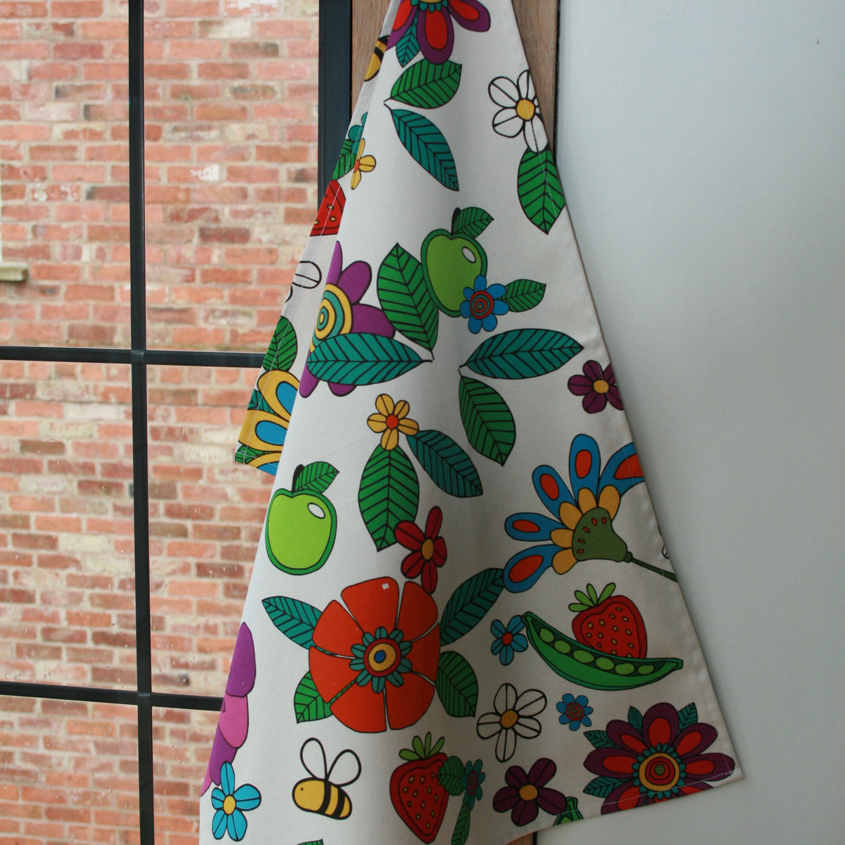 Natural Grower Flower Power organic cotton tea towel hanging in a kitchen