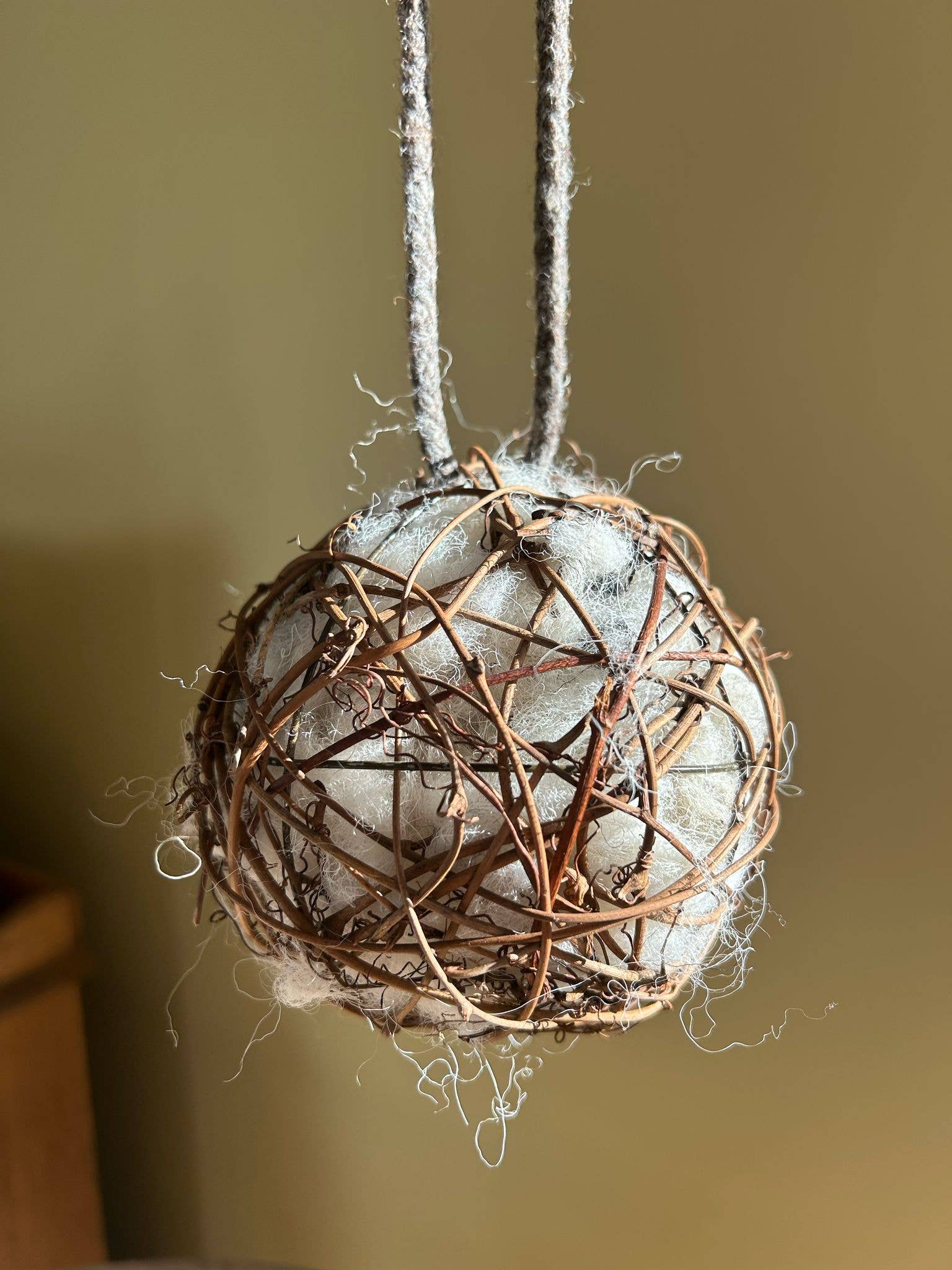 20cm sheep's wool nesting ball with dark woven willow and braided hanging handle