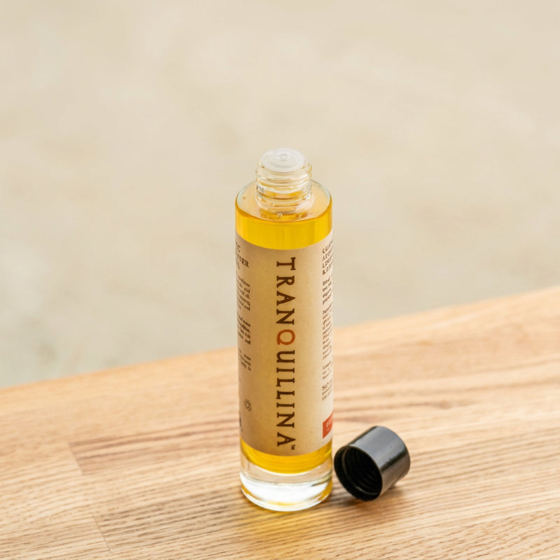 Open bottle of TranQuillina Organic Calendula Oil showing golden botanical oil