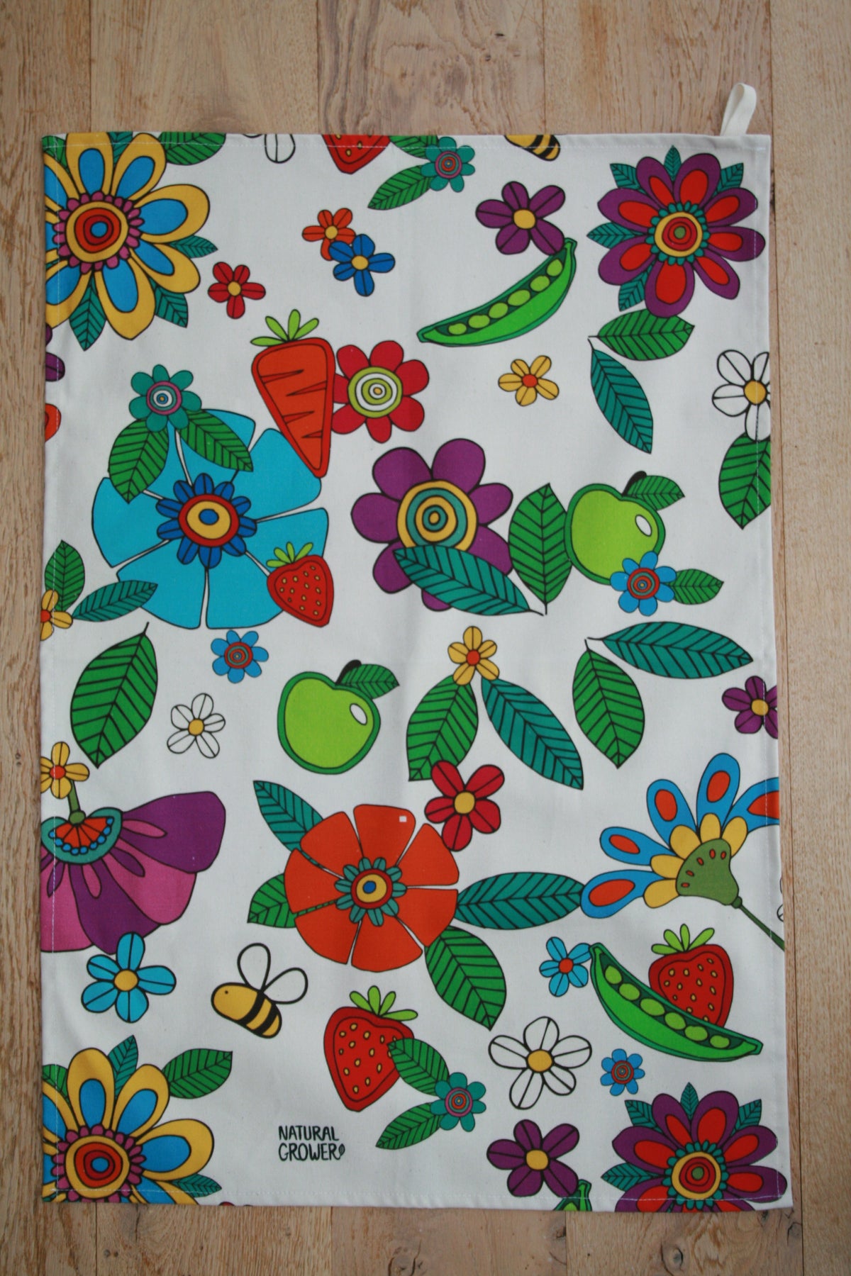 Natural Grower organic cotton tea towel with colourful Flower Power garden design