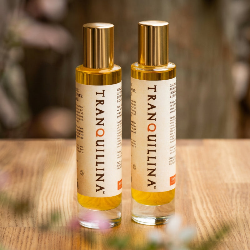 TranQuillina Organic Calendula Body Oil bottles on a wooden surface
